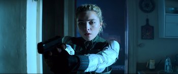 Movie still from “Black Widow” (2021), directed by Cate Shortland – A woman holding a gun while standing in front of a window; Close Up shot, Low angle