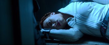 Movie still from “Black Widow” (2021), directed by Cate Shortland – A woman laying on the ground with her head on a pillow; Close Up shot, Overhead angle