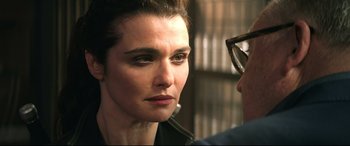 Movie still from “Black Widow” (2021), directed by Cate Shortland – A person wearing glasses and a leather jacket; Close Up shot, Over the shoulder angle