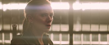 Movie still from “Black Widow” (2021), directed by Cate Shortland – A young woman is standing in front of a window; Close Up shot, Over the shoulder angle