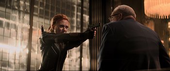 Movie still from “Black Widow” (2021), directed by Cate Shortland – A woman holding a gun in her hand; Medium shot, Over the shoulder angle
