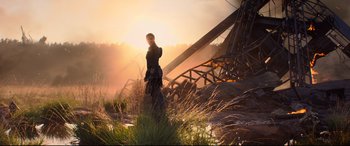 Movie still from “Black Widow” (2021), directed by Cate Shortland – A person standing in a field near a metal structure; Wide shot, Low angle