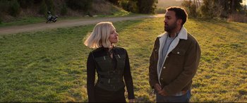 Movie still from “Black Widow” (2021), directed by Cate Shortland – A man and a woman standing in a grassy field; Medium shot, Over the shoulder angle