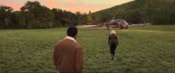 Movie still from “Black Widow” (2021), directed by Cate Shortland – A man and a woman walking in a field towards an airplane; Extreme Wide shot, High angle