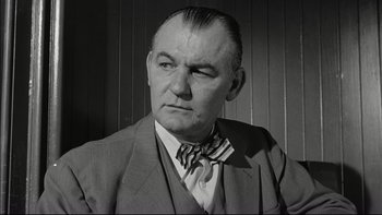 Movie still from “Blackboard Jungle” (1955), directed by Richard Brooks – An older man wearing a suit and a tie; Close Up shot, Low angle