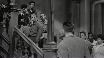 Movie still from “Blackboard Jungle” (1955), directed by Richard Brooks – A group of young men standing next to each other on steps; Wide shot, High angle