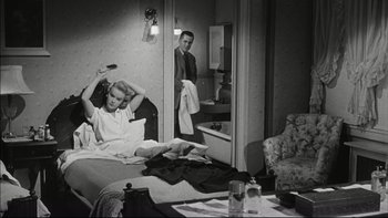 Movie still from “Blackboard Jungle” (1955), directed by Richard Brooks – A man and a woman in a bedroom; Medium shot, High angle