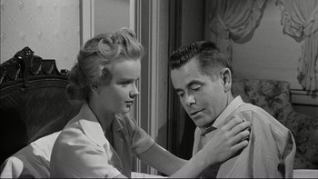 Movie still from “Blackboard Jungle” (1955), directed by Richard Brooks – A man and a woman looking in the same mirror; Medium shot, Low angle