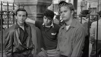 Movie still from “Blackboard Jungle” (1955), directed by Richard Brooks – A group of young men standing next to each other; Medium shot, Low angle