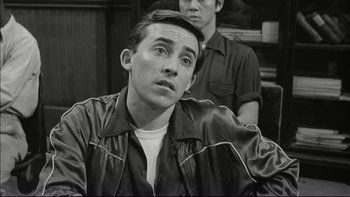 Movie still from “Blackboard Jungle” (1955), directed by Richard Brooks – A black and white photo of a man looking up; Close Up shot, Over the shoulder angle