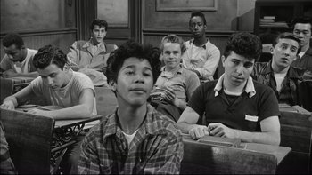 Movie still from “Blackboard Jungle” (1955), directed by Richard Brooks – Black and white photograph of a group of young men sitting in a classroom; Medium shot, High angle