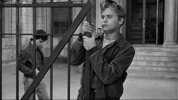 Movie still from “Blackboard Jungle” (1955), directed by Richard Brooks – A young man holding a camera and looking at the camera; Medium shot, Low angle