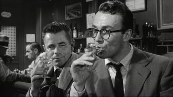 Movie still from “Blackboard Jungle” (1955), directed by Richard Brooks – Two men in suits and ties are drinking wine; Close Up shot, Low angle
