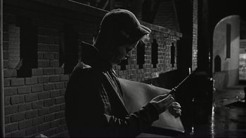 Movie still from “Blackboard Jungle” (1955), directed by Richard Brooks – A man holding a knife in his hands; Medium shot, High angle