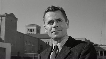 Movie still from “Blackboard Jungle” (1955), directed by Richard Brooks – Black and white photograph of a man wearing a suit and tie; Close Up shot, Low angle