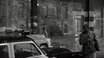Movie still from “Blackboard Jungle” (1955), directed by Richard Brooks – A black and white photo of a city street; Wide shot, Over the shoulder angle