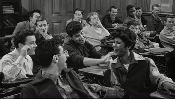 Movie still from “Blackboard Jungle” (1955), directed by Richard Brooks – Black and white photograph of a group of young men; Medium shot, High angle