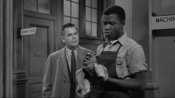 Movie still from “Blackboard Jungle” (1955), directed by Richard Brooks – Two men in suits and ties one is holding a pipe and the other is holding a towel; Medium shot, Low angle