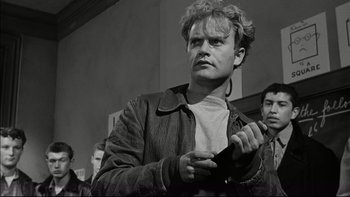 Movie still from “Blackboard Jungle” (1955), directed by Richard Brooks – A black and white photo of a man holding a game controller; Close Up shot, Low angle