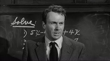 Movie still from “Blackboard Jungle” (1955), directed by Richard Brooks – Black and white photograph of a man in front of a chalkboard; Close Up shot, Over the shoulder angle