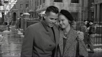 Movie still from “Blackboard Jungle” (1955), directed by Richard Brooks – An older man standing next to an older woman; Medium shot, Low angle