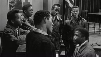 Movie still from “Blackboard Jungle” (1955), directed by Richard Brooks – A black and white photo of a group of young men; Medium shot, High angle