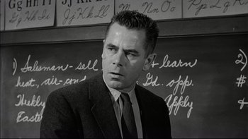 Movie still from “Blackboard Jungle” (1955), directed by Richard Brooks – Black and white photograph of a man in front of a chalkboard; Close Up shot, Low angle