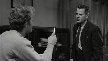 Movie still from “Blackboard Jungle” (1955), directed by Richard Brooks – A man and a woman in a room with a book case in the background; Medium shot, Over the shoulder angle