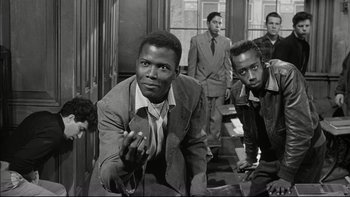 Movie still from “Blackboard Jungle” (1955), directed by Richard Brooks – A black and white photo of a group of men in suits; Medium shot, Low angle