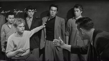 Movie still from “Blackboard Jungle” (1955), directed by Richard Brooks – A group of men standing next to each other in a room; Medium shot, Over the shoulder angle