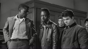Movie still from “Blackboard Jungle” (1955), directed by Richard Brooks – A group of young men standing next to each other in a room; Medium shot, Low angle