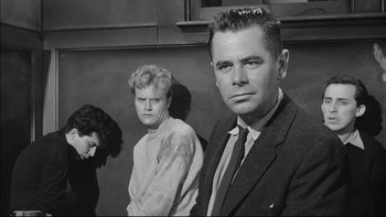 Movie still from “Blackboard Jungle” (1955), directed by Richard Brooks – A black and white photo of a man and two women; Medium shot, Low angle