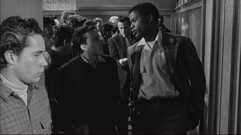 Movie still from “Blackboard Jungle” (1955), directed by Richard Brooks – A black and white photo of two men talking to each other; Medium shot, Over the shoulder angle