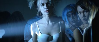 Movie still from “Blade” (1998), directed by Stephen Norrington – A woman in a white top and blue hair; Close Up shot, Low angle