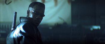 Movie still from “Blade” (1998), directed by Stephen Norrington – A person wearing sunglasses in a room; Close Up shot, Low angle