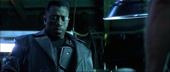 Movie still from “Blade” (1998), directed by Stephen Norrington – A man in a leather jacket looking down at his face; Close Up shot, Low angle