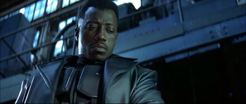 Movie still from “Blade” (1998), directed by Stephen Norrington – A man in a leather jacket looking down at the ground; Close Up shot, Low angle