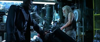 Movie still from “Blade” (1998), directed by Stephen Norrington – A man with long white hair is sitting on the ground; Medium shot, Over the shoulder angle