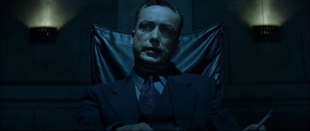 Movie still from “Blade” (1998), directed by Stephen Norrington – A man wearing a suit and tie sitting in a chair; Close Up shot, Low angle