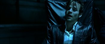 Movie still from “Blade” (1998), directed by Stephen Norrington – A man sitting in a chair with his eyes closed; Close Up shot, High angle