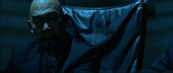 Movie still from “Blade” (1998), directed by Stephen Norrington – A man sitting in a chair in a dark room; Close Up shot, Over the shoulder angle