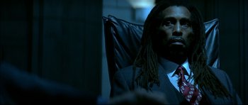 Movie still from “Blade” (1998), directed by Stephen Norrington – A man with dreads sitting in a chair in the dark; Close Up shot, Over the shoulder angle