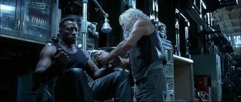 Movie still from “Blade” (1998), directed by Stephen Norrington – A man in a black tank top and a man in a black tank top; Medium shot, Low angle