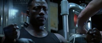 Movie still from “Blade” (1998), directed by Stephen Norrington – A person in a black tank top; Close Up shot, Low angle