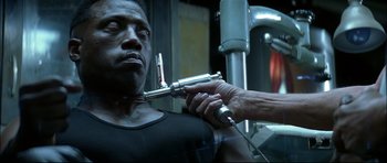 Movie still from “Blade” (1998), directed by Stephen Norrington – A man is getting his head examined by a doctor in a gym; Close Up shot, Over the shoulder angle