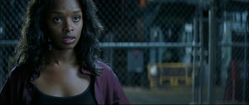Movie still from “Blade” (1998), directed by Stephen Norrington – A young woman with long black hair standing in a parking lot; Close Up shot, Over the shoulder angle