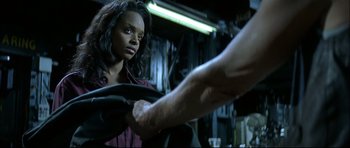 Movie still from “Blade” (1998), directed by Stephen Norrington – A woman standing in front of a man holding something in his hand; Close Up shot, Over the shoulder angle