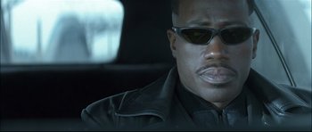 Movie still from “Blade” (1998), directed by Stephen Norrington – A person wearing sunglasses in a car; Close Up shot, Low angle