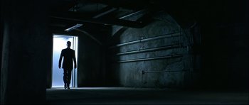 Movie still from “Blade” (1998), directed by Stephen Norrington – A person standing in a dark room with a light on; Extreme Wide shot, Low angle