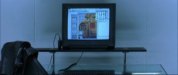 Movie still from “Blade” (1998), directed by Stephen Norrington – A computer monitor sitting on top of a glass table; Wide shot, High angle
